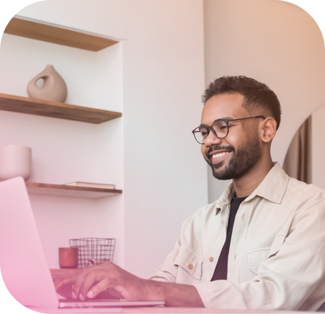 Homem usando notebook e sorrindo